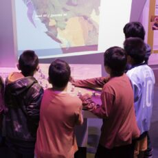 This is a photograph of five young boys gathered around the interactive First Peoples language map.