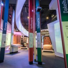 This is a photograph showing the tall, colourful language poles in the welcome forest at the Our Living Languages exhibition.