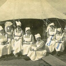 This is an image from the front of a postcard from Murney Pugh showing ten nurses in front of a tent.