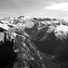 Black and white image of snow-covered mountains from above.