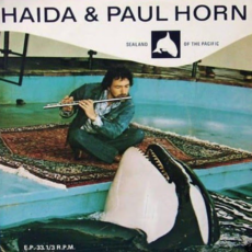 Cover art of Paul sitting on a rug at the edge of a tank with Haidi leaning towards him.